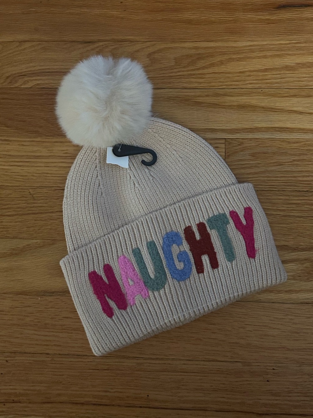 Beige Pom Pom Beanie with 'NAUGHTY' Multicolor Letters